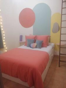 een slaapkamer met een bed met rode lakens en kleurrijke muren bij Appartement Avignon Centre ville intra muros in Avignon