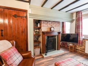a living room with a fireplace and a tv at Midships Cottage in Whitby