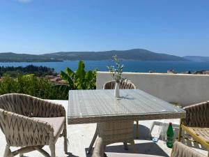 a table and chairs with a view of the water at Holliday Tivat in Peani