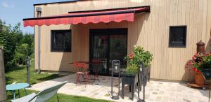 a building with a table and chairs and a patio at Dives Le petit Gîte in Dives-sur-Mer