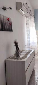 Una encimera de cocina con un jarrón de flores encima. en A un passo dal cuore, en Mesagne