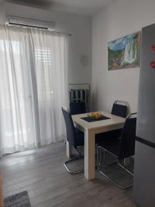ein Esszimmer mit einem weißen Tisch und Stühlen in der Unterkunft Vesna Meterize A2+1 in Šibenik