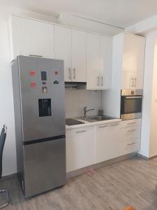 eine Küche mit weißen Schränken und einem Kühlschrank aus Edelstahl in der Unterkunft Vesna Meterize A2+1 in Šibenik
