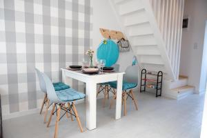 a dining room with a white table and chairs at Emma Apartamenty in Gostyń