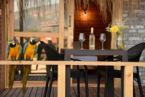 dois pássaros sentados num carril ao lado de uma mesa em Green Pine Bungalows & Beach Luxury Concept em Oludeniz