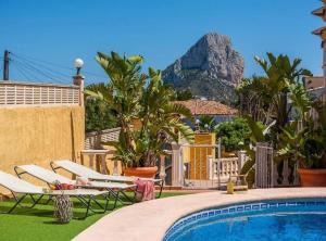 una piscina con sedie a sdraio e una montagna sullo sfondo di Casa Rose - 4-Bed villa with private pool in Calpe a Calpe