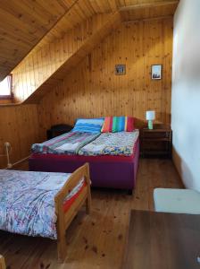a bedroom with two beds in a wooden cabin at Stadnina koni Tarka in Zwierzyniec