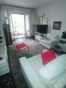Ampi spazi, a piedi in centro. في تريفيزو: غرفة معيشة مع أريكة بيضاء ومخدة حمراء