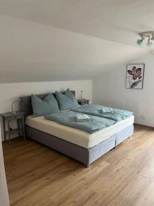 Bett in einem Schlafzimmer mit Holzboden in der Unterkunft Mountain View Apartment in Innsbruck