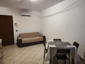 Habitación con cama, mesa y sillas. en Appartamento Magnolia 2, en Pomezia