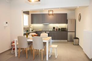 eine Küche mit einem Tisch und Stühlen sowie einem Kühlschrank in der Unterkunft Olympia luxury apartment in Marousi in Athen
