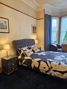 1 dormitorio con 1 cama y 1 mesa con lámpara en Smiths Guest House, en Edimburgo