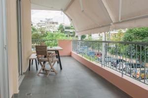 uma varanda com uma mesa e cadeiras em Olympia luxury apartment in Marousi em Atenas