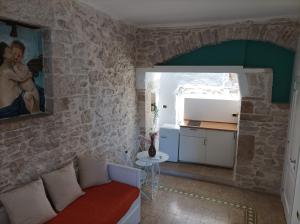 a living room with a couch in a stone wall at MaGia b&b Corato in Corato