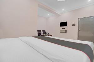 Habitación blanca con cama y TV en Collection O Hotel Chirag StayÃƒÂ©Ã‹â€ Ã‚Â¥ÃƒÂ¦Ã‚ÂªÃ…Â¡, en Hyderabad