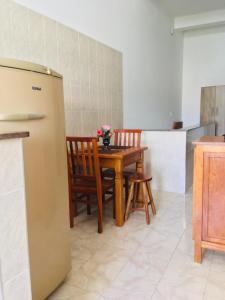 a kitchen with a table and chairs and a refrigerator at Hospedagem Alto da Montanha in Cunha