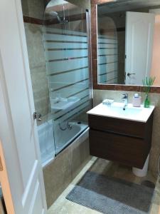 ein Bad mit einem Waschbecken und einer Dusche mit einem Spiegel in der Unterkunft Villa puerto banuus Marbella in Marbella