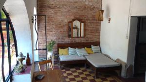 聖馬科斯塞拉利昂的住宿－Jaracanda Hostel San Marcos，带沙发和砖墙的客厅