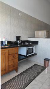 a kitchen with a stove and a microwave in it at Hospedagem Alto da Montanha in Cunha
