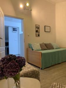 1 dormitorio con 1 cama y 1 mesa con flores en Cozy apartment en Herceg-Novi