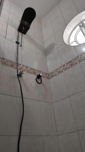 a shower with a blow dryer in a room at Hospedagem Alto da Montanha in Cunha