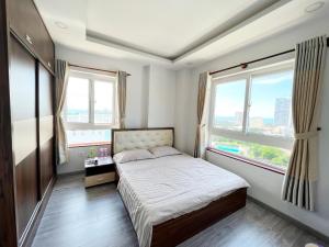 a small bedroom with a bed and two windows at Ngọc Duyên Homestay- Central Vung Tau, near Lotte Mart in Vung Tau