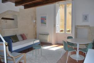 a living room with a bed and a table and chairs at Palazzo della Contessa - Suites & Breakfast in Lecce