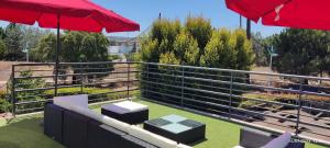 a fence with two tables and two umbrellas at Villa De Lux with pool in Quinta do Anjo