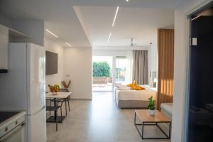 Thimios Suites Adults Only في أكارافي: غرفة نوم مع سرير وغرفة معيشة