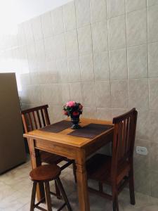 a wooden table with two chairs and a vase with flowers on it at Hospedagem Alto da Montanha in Cunha