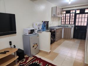 a kitchen with a refrigerator and a microwave at Zuri Homes 2 in Keruguya
