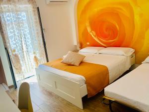 1 dormitorio con 2 camas y pared de color naranja en B&B Di Fiore en Peschici