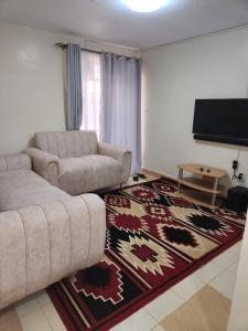 sala de estar con sofá y TV de pantalla plana en Zuri Homes 2 en Keruguya