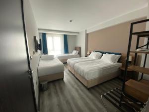 ein Hotelzimmer mit 2 Betten und einer Leiter in der Unterkunft Yalçındağ Otel Burdur in Burdur