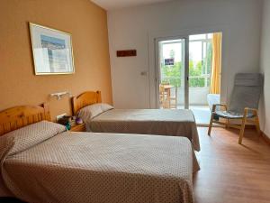 une chambre d'hôtel avec deux lits et une fenêtre dans l'établissement Apartamentos Sol y Luna 3000, à Peñíscola 29 autres photos
