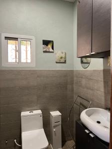 a bathroom with a white toilet and a sink at Yazmin’s studio apartments in Lamin