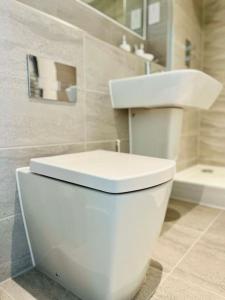 uma casa de banho com um WC branco e um lavatório. em Stunning one bedroom apartment in Old Trafford em Manchester