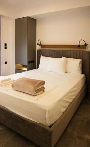 a large white bed with a brown blanket on it at P J Luxury Suites in Serres