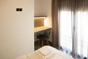 een slaapkamer met een bed, een bureau en een stoel bij P J Luxury Suites in Serres