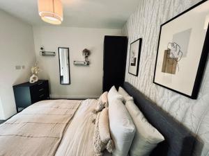 ein Schlafzimmer mit einem Bett mit Kissen darauf in der Unterkunft Stunning one bedroom apartment in Old Trafford in Manchester