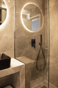 a bathroom with a shower with a sink and a mirror at P J Luxury Suites in Serres