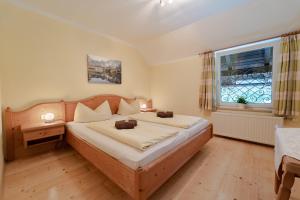 Un dormitorio con una cama grande y una ventana en Bio Bauernhof Eggerhof, en Strobl
