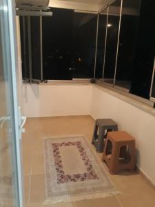 a room with a rug and a window and a stool at günlük aylık kralık daire in Arsin