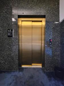 porta di un ascensore dorato in un edificio di Nam Hotel a Prizren