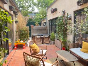 d'une terrasse avec des chaises et une table. dans l'établissement PARIS Maison Exception Terrasse Jacuzzi Parking gratuit, à Saint-Ouen