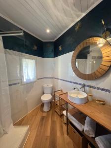 a bathroom with a toilet and a sink and a mirror at au coeur de la demeure in Lieuran-lès-Béziers +4 photos