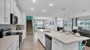 a large kitchen with white cabinets and a counter top at 1840 Caribbean View in Kissimmee