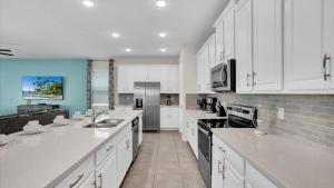 a large white kitchen with white cabinets and appliances at 1840 Caribbean View in Kissimmee