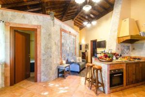 a kitchen with a counter and a table in a room at Villa del Gelso Chalet nel Parco dellEtna in Mascali