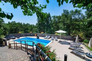 a swimming pool with chairs and an umbrella at Villa del Gelso Chalet nel Parco dellEtna in Mascali